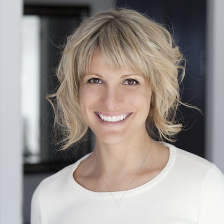 Women in a cream top smiling with short blond hair 